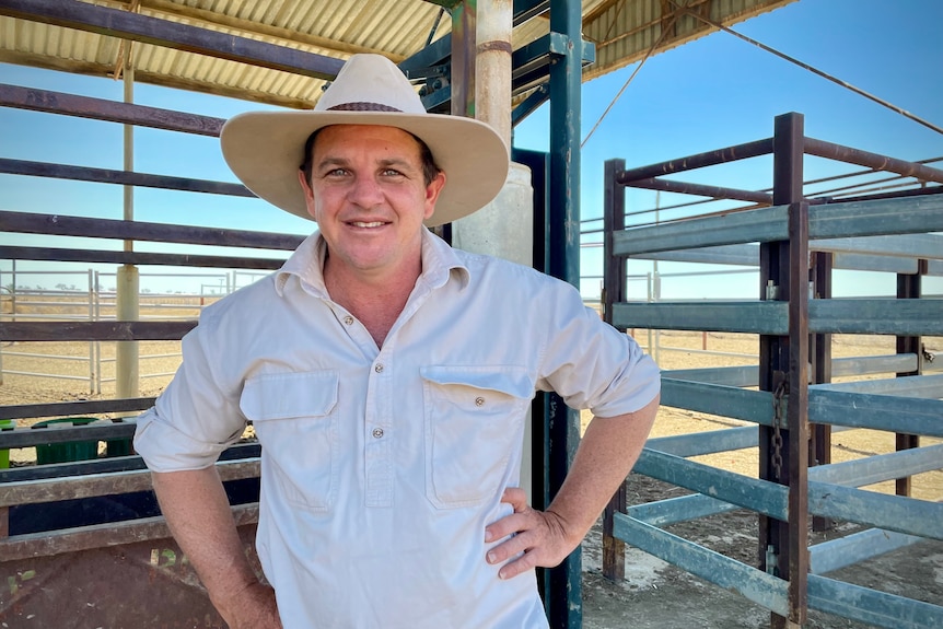 A man standing in front of cattle yards on an outback station