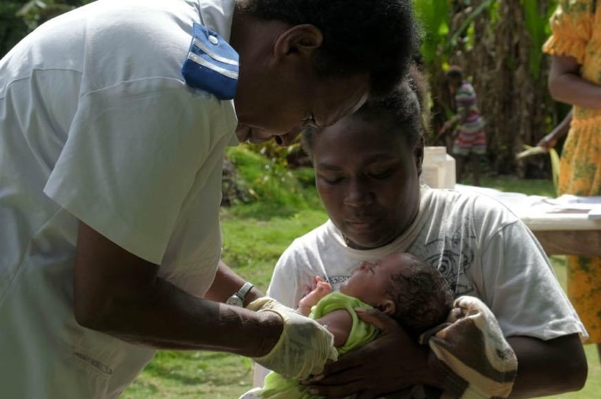 A nurse in Vanuatu vaccinates a baby using medicine delivered by drone.