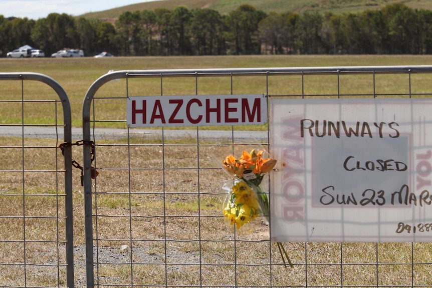 Flowers laid by victims' family and friends outside the airport fence at Queensland's Caboolture airfield.