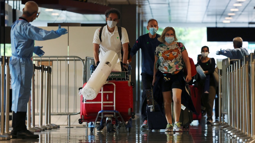 Travellers walking through an airport