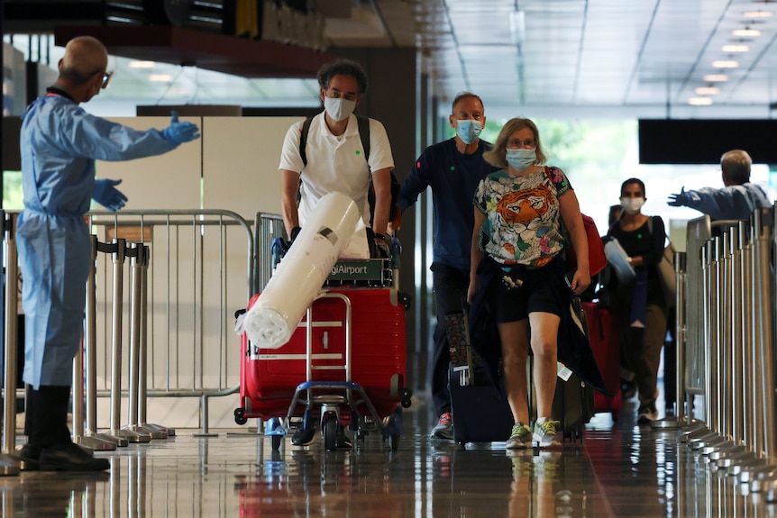 Travellers walking through an airport