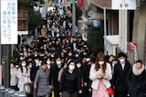 People wear masks as they commute during the morning rush hour in Tokyo.