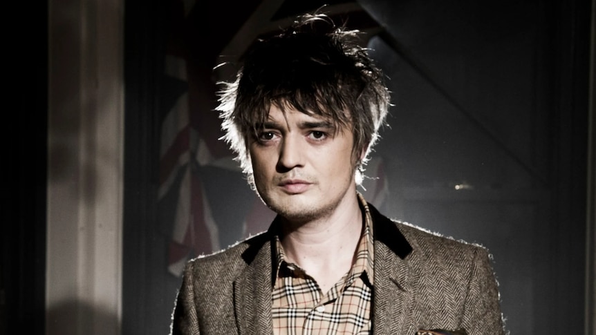 Pete Doherty of British band The Libertines stands with a light shining behind his head