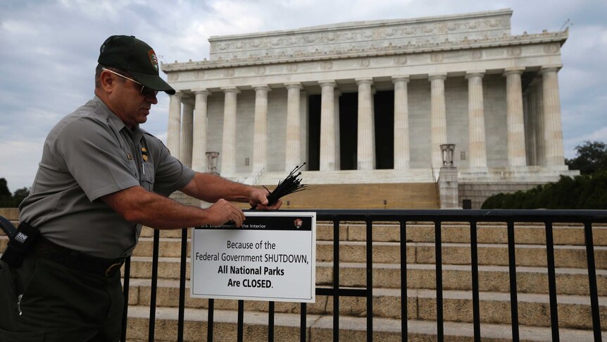 A worker places a sign barring visitors to the Lincoln Memorial in Washington, October 1, 2013