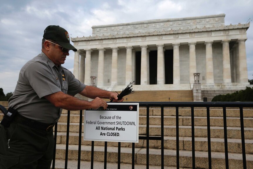 A worker places a sign barring visitors to the Lincoln Memorial in Washington, October 1, 2013
