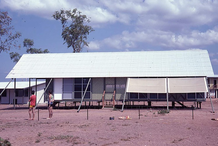 A coloured archival photo of tropical housing in Darwin.