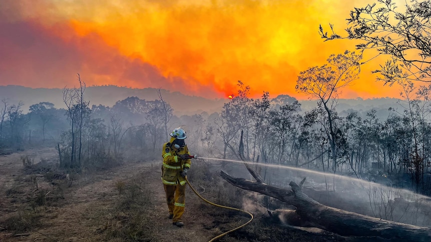 A firefighter at work on a fireground in the country.