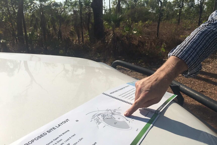 Pointing at a map for proposed lithium mine near Darwin
