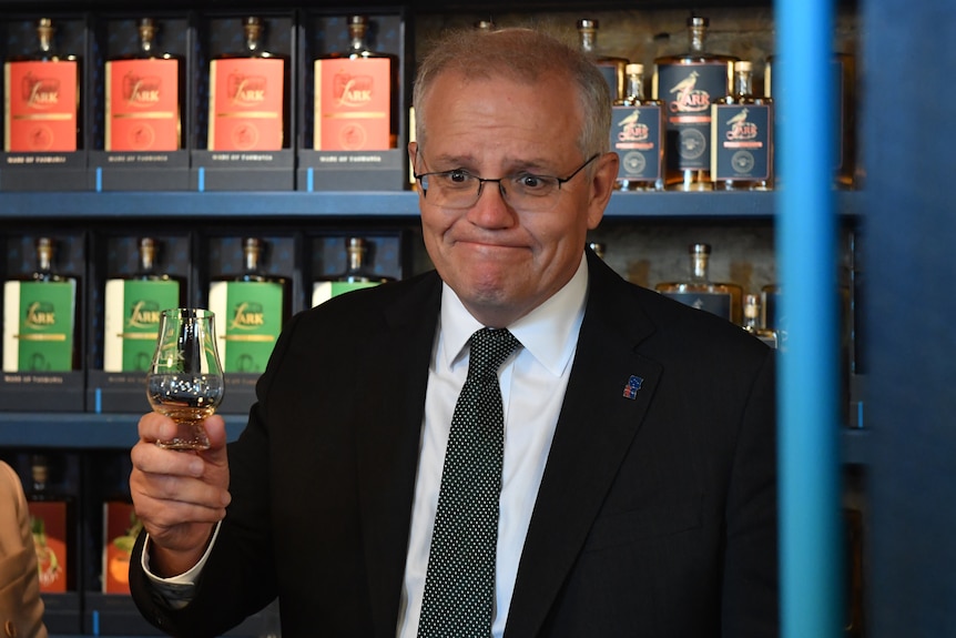 Scott Morrison holds a glass of whisky during a visit to a distillery.