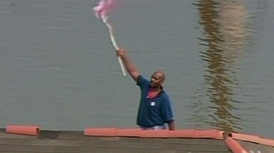 Call for help ... a man waves a flag from his rooftop to attract rescuers
