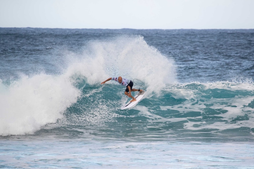 Kelly Slater sprays water as he turns on a wave