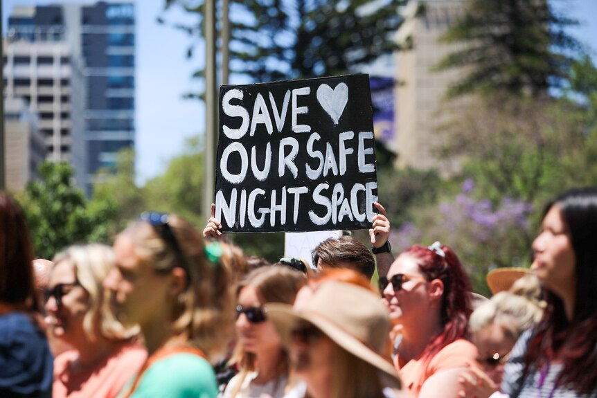 Un manifestante sostiene un cartel que dice: Salvad nuestro espacio nocturno.