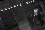 A worker walks past the Reserve Bank building in Sydney.