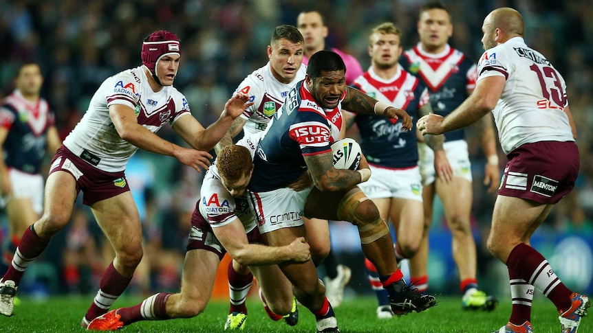 The Roosters' Frank-Paul Nuuausala is tackled by Manly players at the Sydney Football Stadium.