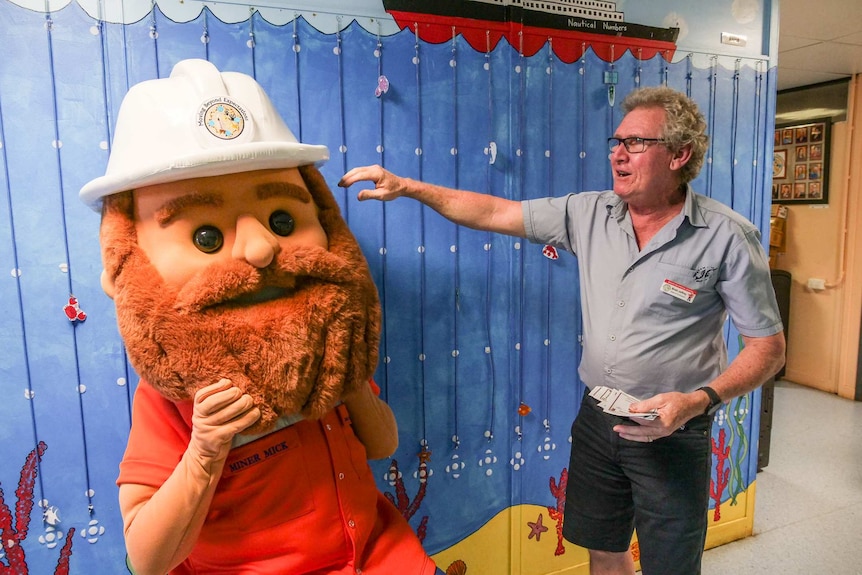 A man dressed in a miner's costume and a school teacher at Mount Isa Special School