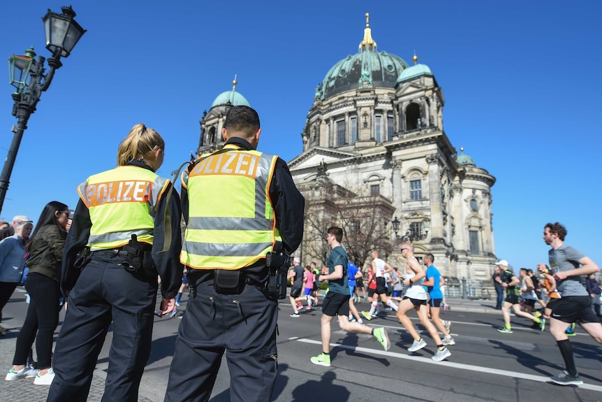 Police observe the half marathon in front of the Berlin Cathedral.