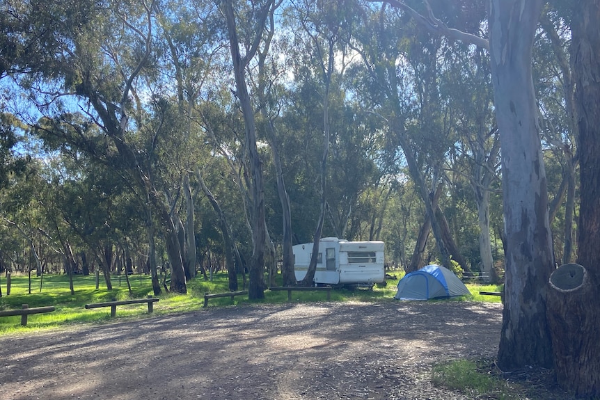 A photo of a caravan and tent at a camping site