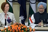 Julia Gillard watches Manmohan Singh speak after agreement signing in New Delhi.