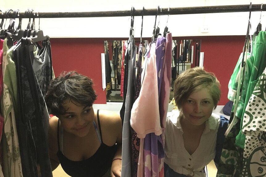 Kate Brown and Ellaby Kenneth hide in among garments on a clothing rack