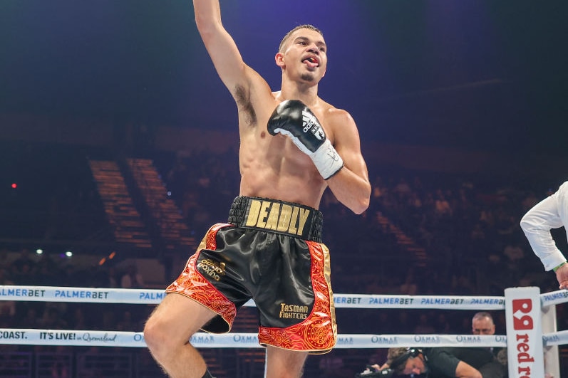 A boxer celebrates in the ring following a fight. 