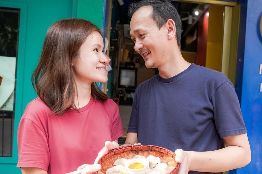 A couple looking into each others' eyes with fried Nepali dumplings in front of them