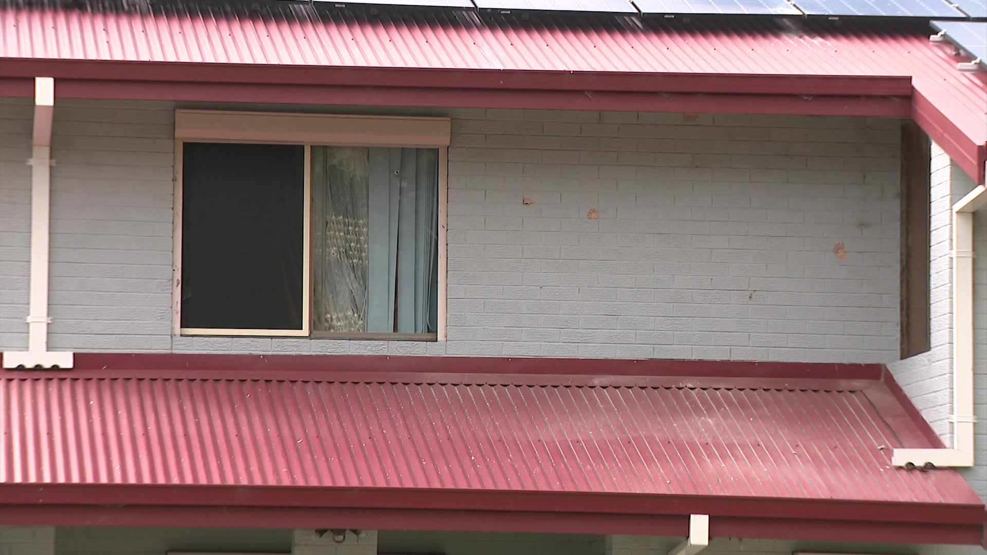 The upper floor of a suburban home riddled with bullet holes. 