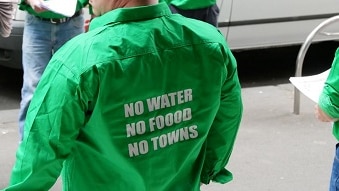 A the back of a green shirt reads no water no food no towns.