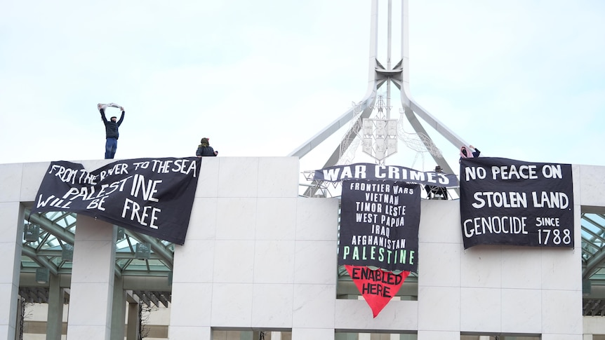 Black banners wave along the front of parliament.