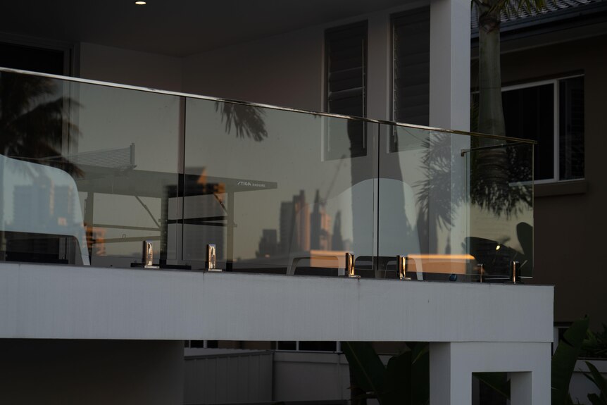 The Gold Coast skyline reflected in a glass railing.