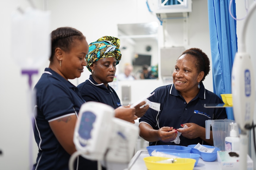 Three women clean medical equipment. 