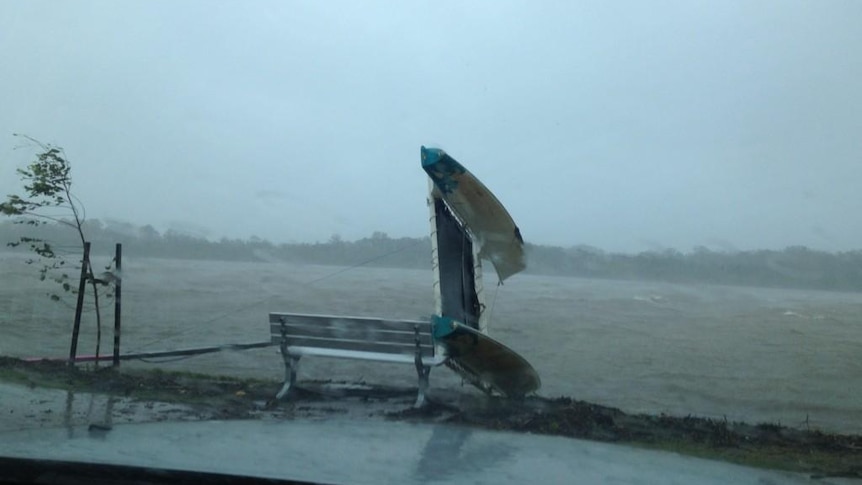 A small boat is overturned in wild weather on the Maroochy River.