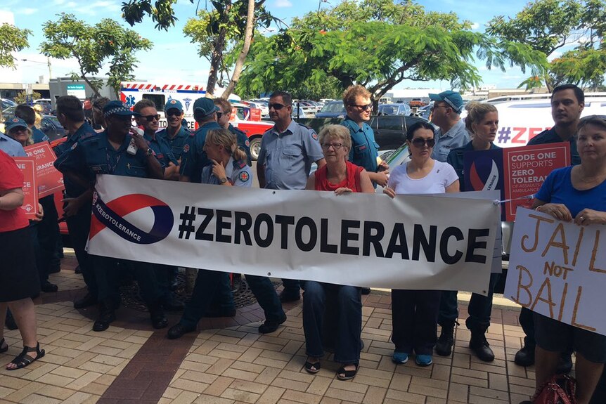Paramedics hold a sign that says #ZeroTolerance.
