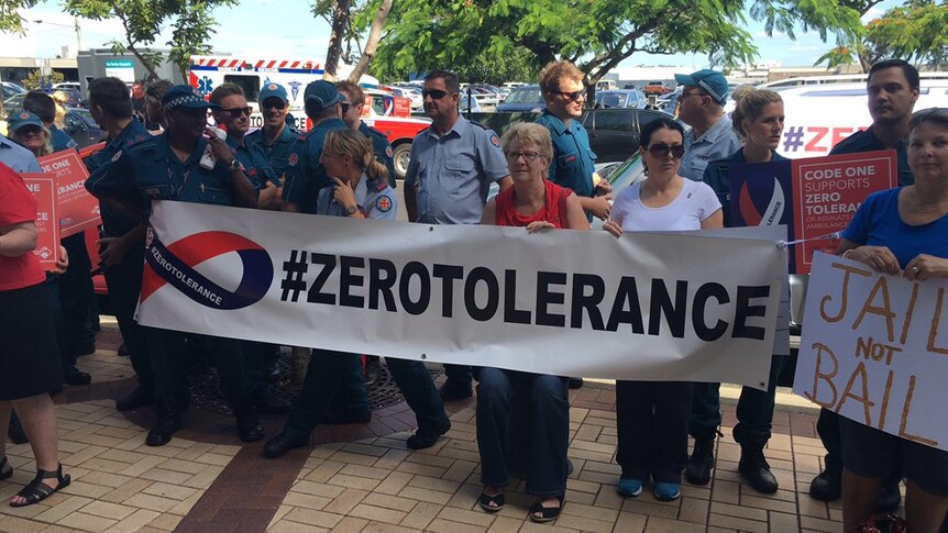 Paramedics hold a sign that says #ZeroTolerance.