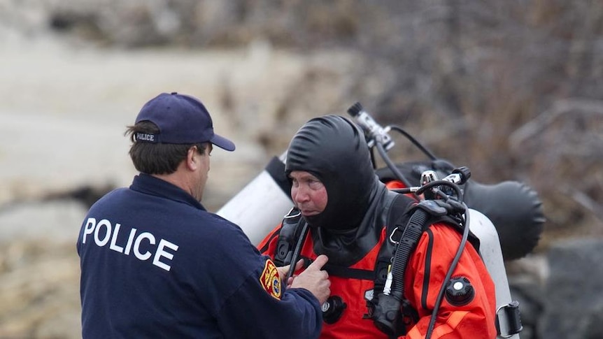 A police diver gets ready to search for human remains in the waters of Hemlock Cove near Point Lookout.