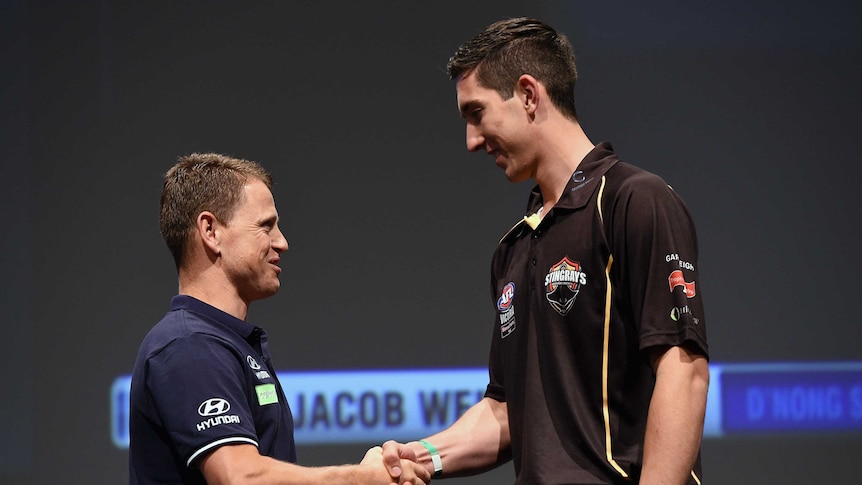 Jacob Weitering shakes the hand of Carlton coach Brendan Bolton