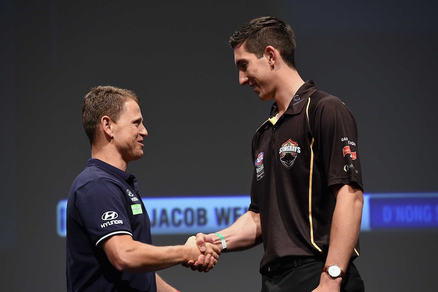 Jacob Weitering shakes the hand of Carlton coach Brendan Bolton