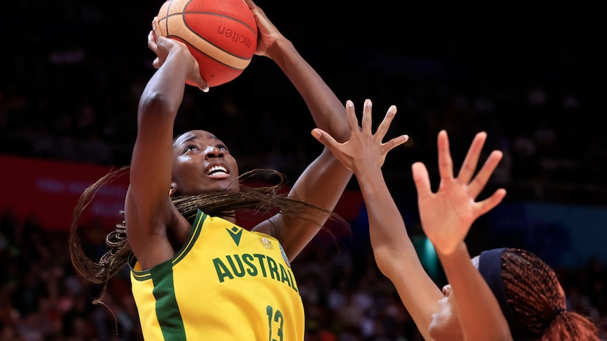 Australia's Ezi Magbegor shoots as a player puts their arms up to defend. 
