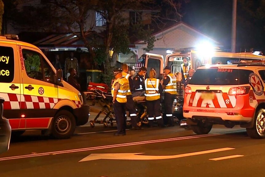 Emergency ambulance cars in the night working on a person obscured