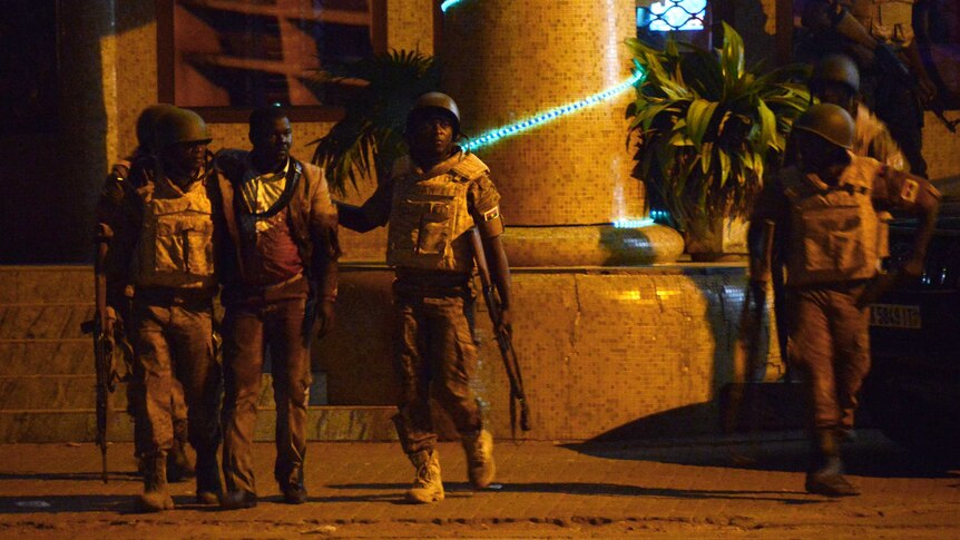 Burkina Faso's soldiers evacuate an injured man from the Splendid hotel.