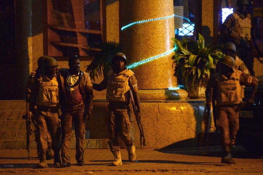 Burkina Faso's soldiers evacuate an injured man from the Splendid hotel.