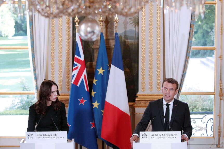 Jacinda Ardern and Emmanuel Macron in a room before lecterns