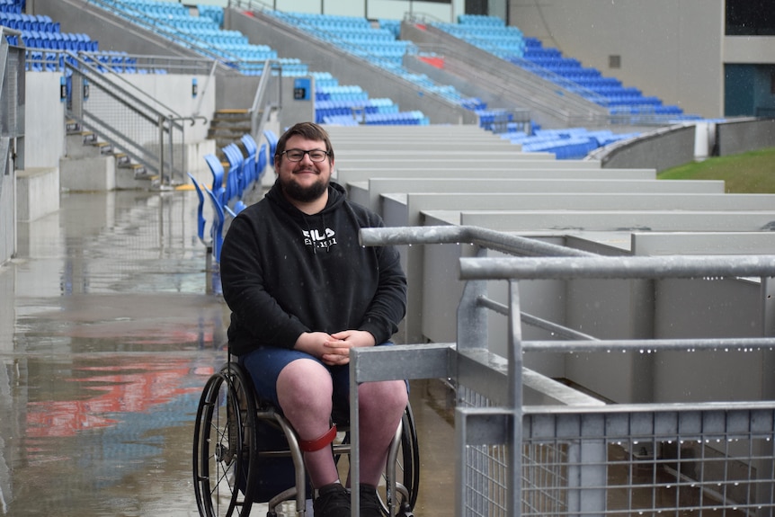 Man smiling at camera, he is sitting in a wheelchair