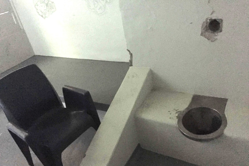 A basic toilet and plastic chair inside a cell in the isolation wing of the Don Dale prison.