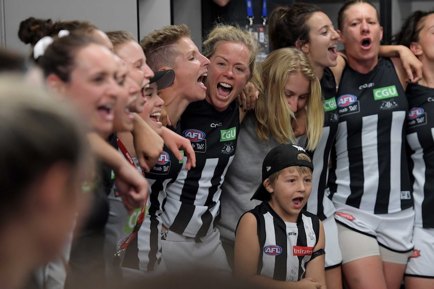 Kate Sheahan sings with her Collingwood team-mates as they celebrate an AFLW win over the Bulldogs.