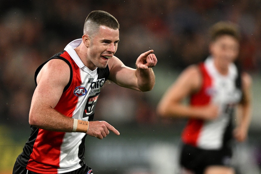 A St Kilda AFL player points a finger as he celebrates a goal against Essendon.