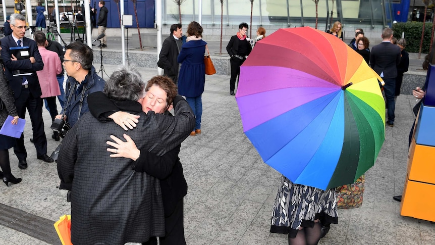 Supporters hug outside the High Court after it decided to uphold the Government's same-sex marriage postal survey.