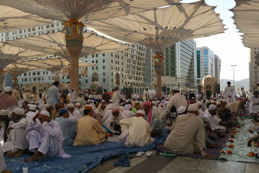 A large crowd of people outside a mosque