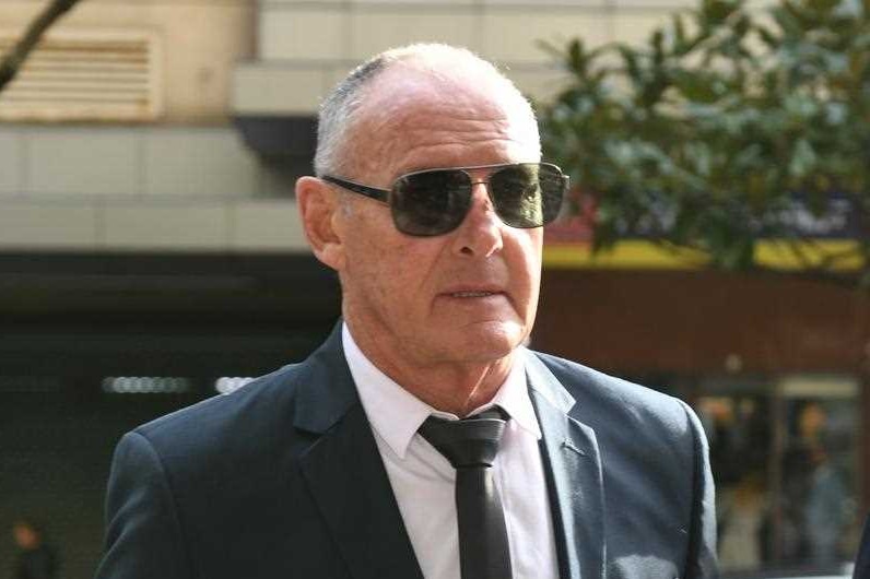 A man in sunglasses arriving at court.