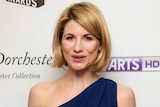 A headshot of a woman with a blonde bob smiling at the camera on the red carpet.