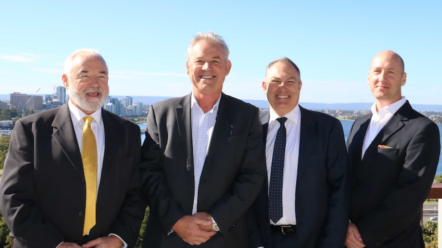 Four men with city in background